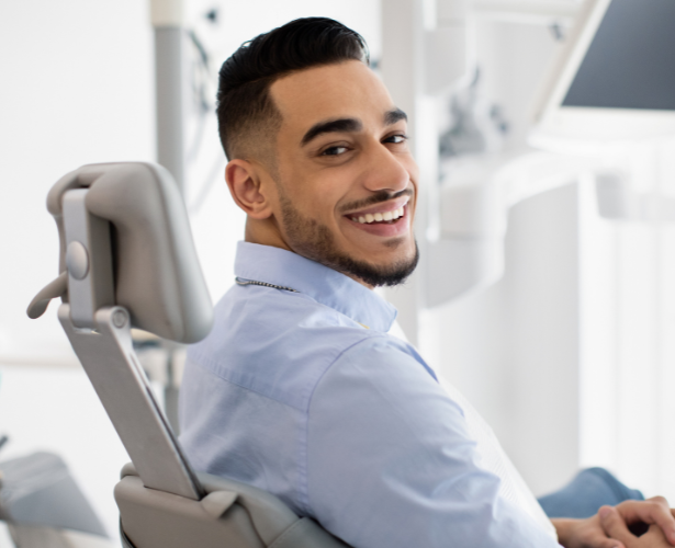 Smiling man in a dental chair at a modern clinic