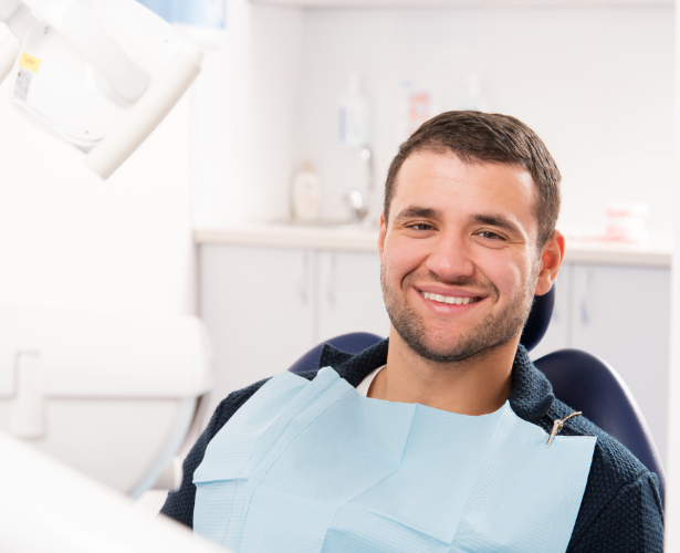 Smiling male patient sitting in a dental chair