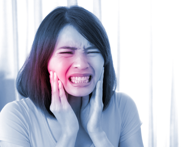 Woman with jaw pain and sensitivity indicating tooth infection