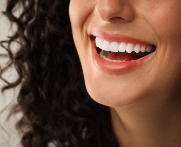 Side close-up of a woman’s straight white teeth and gums