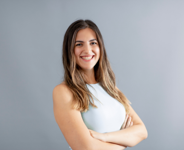 Confident woman standing with arms crossed and smiling